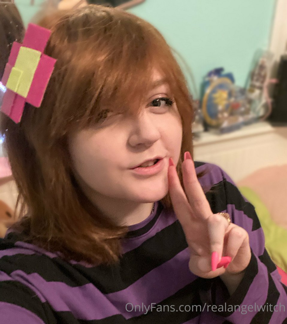 A woman lies on a bed her body draped in lingerie her gaze fixed on the lens.